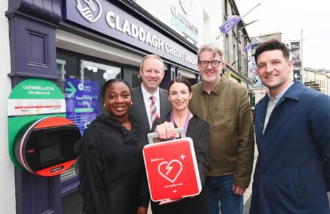 Image of three men and two women holding Defibrillator