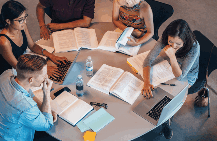 Rental scam. Image of students sitting around a table.